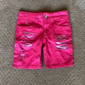 Pink shorts with sequenced rips.